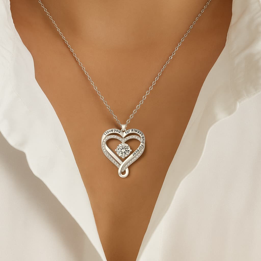 Woman wearing The Eternal Heart silver necklace with a white open-collar shirt