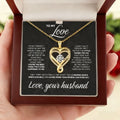 Gold heart-shaped necklace with a message card held by a hand