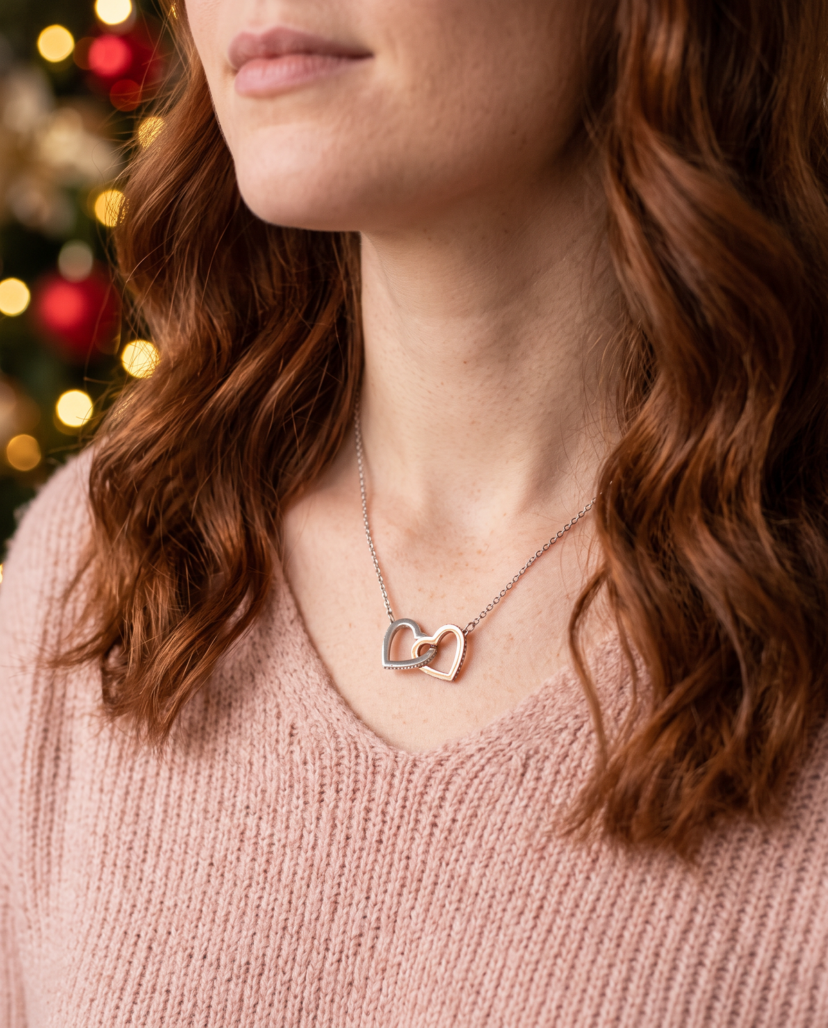 Woman wearing The Always Connected Hearts interlocking silver and rose gold heart necklace