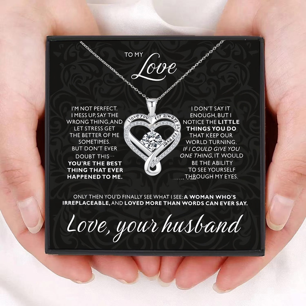 Heart-shaped necklace with sentimental message card held by hands