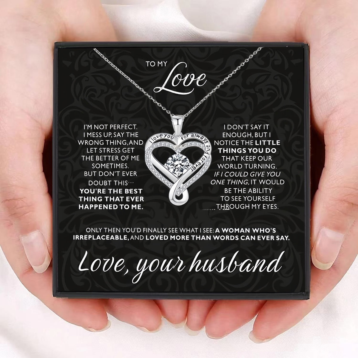Heart-shaped necklace with sentimental message card held by hands