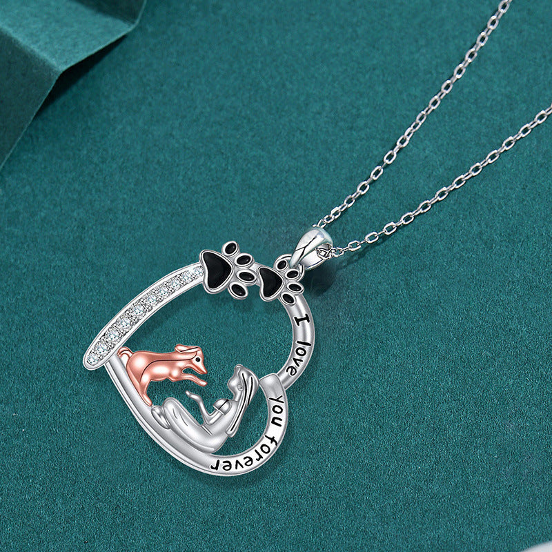 The Dog Mom Heart silver paw print heart necklace on a teal background
